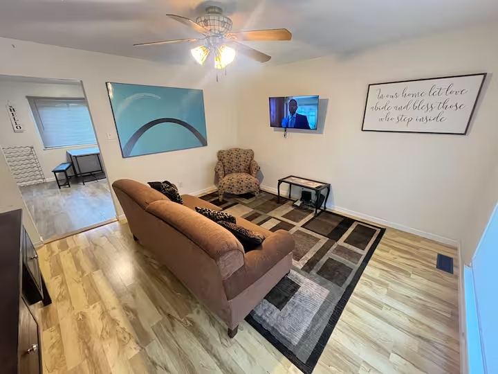 Furnished living room with seating, a patterned rug and an adjoining dining area.